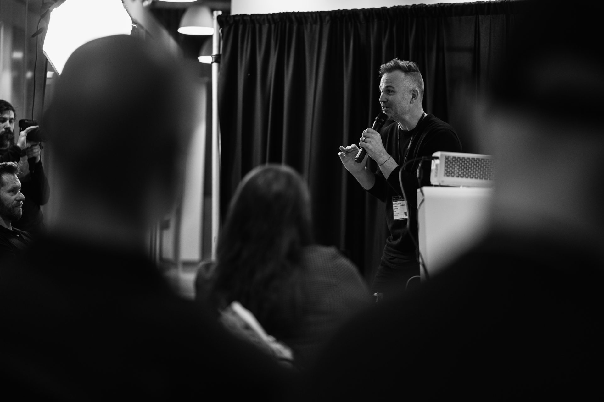 Bryan J Noel speaking. Black and white, high contrast.
